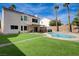 Spacious backyard features a pool, lush artificial grass, and mature palm trees at 2724 Monrovia Dr, Las Vegas, NV 89117