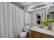 Cozy bathroom featuring a shower with curtain, toilet, sink, and mirror at 2724 Monrovia Dr, Las Vegas, NV 89117