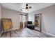 Neutral bedroom with window, hardwood flooring, ceiling fan, and decorative mirror at 2724 Monrovia Dr, Las Vegas, NV 89117