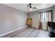 Neutral bedroom with window, hardwood flooring, ceiling fan, and decorative mirror at 2724 Monrovia Dr, Las Vegas, NV 89117