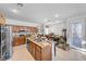 Bright kitchen with tile flooring, stainless steel appliances, wooden cabinets, and an island sink at 2804 Gallant Hills Dr, Las Vegas, NV 89135