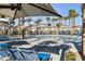 Resort-style community pool with palm trees, comfortable lounge chairs and shade structures for relaxation at 2846 Cerulean Stars Ln # 1, Las Vegas, NV 89183