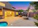 Backyard patio featuring a stone fire pit, outdoor dining area, and lush landscaping at 2908 Ferrand Ct, Henderson, NV 89044