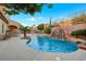 Inviting backyard pool with a rock waterfall, lush landscaping, and ample space for outdoor activities at 2908 Ferrand Ct, Henderson, NV 89044