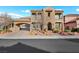 Elegant two-story home with stucco exterior, dual balconies, arched entryway, and a porte-cochere leading to the garage at 2908 Ferrand Ct, Henderson, NV 89044
