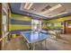 Bright game room with ping pong table, foosball table, lounge area and large windows with pool view at 2908 Ferrand Ct, Henderson, NV 89044