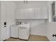 Bright laundry room equipped with modern washer, dryer, and ample cabinet space at 2908 Ferrand Ct, Henderson, NV 89044