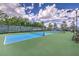 Outdoor pickleball courts featuring blue courts, green perimeter, surrounding trees, and comfortable chairs at 2908 Ferrand Ct, Henderson, NV 89044