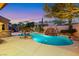 Inviting pool area featuring a rock waterfall, lush landscaping, and relaxing hot tub at 2908 Ferrand Ct, Henderson, NV 89044
