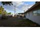 Spacious backyard with gravel, a covered patio with dining set, and privacy fencing at 301 Falcon Ln, Las Vegas, NV 89107
