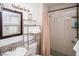 Bathroom featuring granite countertop vanity, decorative shelving and tiled shower with curtain at 301 Falcon Ln, Las Vegas, NV 89107