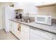 Close-up of kitchen counter with stainless steel sink, white microwave, and white cabinets at 301 Falcon Ln, Las Vegas, NV 89107