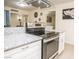 Close-up of kitchen, with white cabinets, granite countertop, and stainless steel oven and cooktop at 301 Falcon Ln, Las Vegas, NV 89107