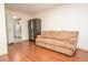 Living room showcasing a beige couch, wardrobe, and wood flooring, leading into a modern kitchen at 301 Falcon Ln, Las Vegas, NV 89107
