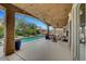 Relaxing covered patio with a sparkling pool, lush landscaping, and comfortable outdoor seating, perfect for entertaining at 3723 Robin Knot Ct, North Las Vegas, NV 89084