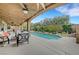 Relaxing covered patio area overlooking a pristine pool and meticulously landscaped backyard at 3723 Robin Knot Ct, North Las Vegas, NV 89084