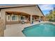 Inviting backyard with a sparkling pool, covered patio with outdoor seating, and lush landscaping at 3723 Robin Knot Ct, North Las Vegas, NV 89084