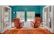 Inviting living room with turquoise walls, plush seating, and a view of the outdoor pool through sliding glass doors at 3723 Robin Knot Ct, North Las Vegas, NV 89084