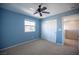 Stylish blue bedroom with a ceiling fan and ample closet space offers a comfortable and organized retreat at 3915 Enchanted Wells Ave, North Las Vegas, NV 89031
