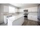 Bright kitchen features stainless steel appliances, white cabinets, stone countertops, and an island at 3915 Enchanted Wells Ave, North Las Vegas, NV 89031