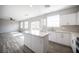 Kitchen with a center island opens to the bright living area with large windows at 3915 Enchanted Wells Ave, North Las Vegas, NV 89031