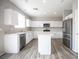 Bright kitchen features stainless steel appliances, white cabinets, stone countertops, and an island at 3915 Enchanted Wells Ave, North Las Vegas, NV 89031