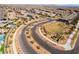An aerial view captures a community with winding roads and lush landscaping near desert at 397 American Dipper St, Las Vegas, NV 89138