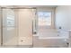 Bathroom featuring a tub, glass-door shower, and a vibrant window with blue accents at 397 American Dipper St, Las Vegas, NV 89138