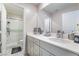 Stylish bathroom featuring double vanity, a large mirror, white cabinets and a shower with glass doors at 397 American Dipper St, Las Vegas, NV 89138