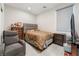 Comfortable bedroom with a gray upholstered bed, chair, TV, and wood dresser at 397 American Dipper St, Las Vegas, NV 89138