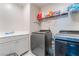 Modern laundry room with gray cabinets, a stainless steel sink, and front-loading washer and dryer at 397 American Dipper St, Las Vegas, NV 89138