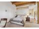 Bedroom with exposed beams features a cozy bed and an adjacent bathroom at 519 N Racetrack Rd, Henderson, NV 89015