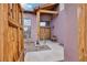 Inviting entrance showcasing a stucco home with wooden support beams and a gravel-laid yard and a rustic, open wooden gate at 519 N Racetrack Rd, Henderson, NV 89015