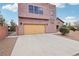 Attached garage with desert landscaping and a stucco facade at 519 N Racetrack Rd, Henderson, NV 89015