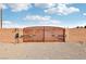 Property features a secure, automated gate at the entrance with brick pillars and gravel drive at 519 N Racetrack Rd, Henderson, NV 89015