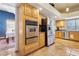 Well-equipped kitchen with stainless steel appliances, wooden cabinets, and a dining area in the background at 519 N Racetrack Rd, Henderson, NV 89015