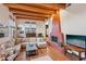Cozy living room featuring a large fireplace, wood floors, exposed wood beam ceiling, and comfortable seating at 519 N Racetrack Rd, Henderson, NV 89015