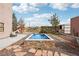 A stunning backyard featuring a raised swimming pool, stone accents, and charming landscaping, perfect for outdoor relaxation at 519 N Racetrack Rd, Henderson, NV 89015