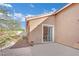 View of a small backyard with a wooden deck, stucco wall, and desert landscaping at 5438 Cholla Cactus Ave, Las Vegas, NV 89141
