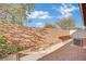 Desert landscaping with trees along back fence line, and a gravel drainage area at 5438 Cholla Cactus Ave, Las Vegas, NV 89141