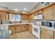 Cozy kitchen features wood cabinets, white countertops, tile backsplash and modern stainless appliances at 5438 Cholla Cactus Ave, Las Vegas, NV 89141