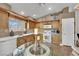 Bright eat-in kitchen with wood cabinets, white appliances, and a glass table and chairs at 5438 Cholla Cactus Ave, Las Vegas, NV 89141