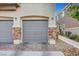 Attached garage with stylish stone accents and brick paver driveway at 5537 Parlay Way # 101, Las Vegas, NV 89122