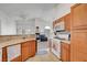 Open kitchen features wood cabinets and modern appliances overlooking the cozy living area at 5537 Parlay Way # 101, Las Vegas, NV 89122
