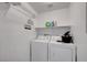 Functional laundry room featuring a washer, dryer, and convenient shelving for storage solutions at 5537 Parlay Way # 101, Las Vegas, NV 89122