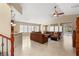 Open-concept living room with tile flooring, large windows, ceiling fan and comfortable sofa at 5809 Sagamore Canyon St, North Las Vegas, NV 89081