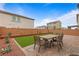 This backyard features a patio with pavers, a dining table with seating, and artificial turf at 6346 Rock Strm Ln, Las Vegas, NV 89141