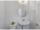 Powder room featuring pedestal sink, oval mirror, and flower accent at 6346 Rock Strm Ln, Las Vegas, NV 89141