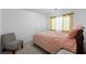 Cozy bedroom featuring a queen-size bed, a comfy chair, and natural light at 6346 Rock Strm Ln, Las Vegas, NV 89141