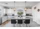 Bright kitchen with granite counters, white cabinets, stainless appliances, a large island with seating, and pendant lighting at 6346 Rock Strm Ln, Las Vegas, NV 89141